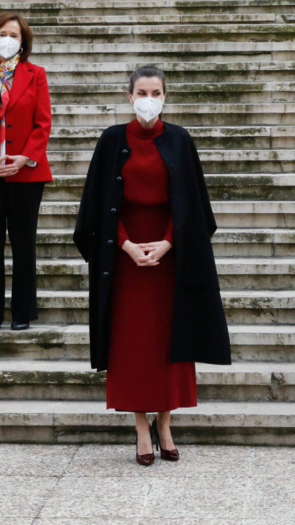 A su llegada, la reina Letizia vestía un abrigo de lana negro estilo capa Carolina Herrera de la colección de 2017.