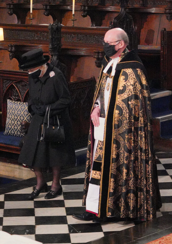La reina Isabel II es conducida por el Decano de Windsor al Quire of St George’s Chapel en el Castillo de Windsor, Berkshire, para el funeral del Duque de Edimburgo el 17 de abril de 2021
