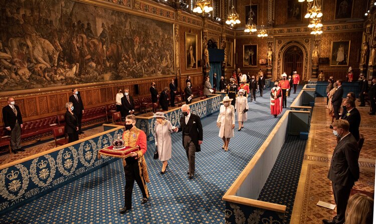 Britain’s Queen Elizabeth II and Britain’s Prince Charles, Prince of Wales walk behind the Imperial State Crown as they process through the Royal Gallery, before the Queen’s Speech, during the State Opening of Parliament at the Houses of Parliament in London on May 11, 2021, which is taking place with a reduced capacity due to Covid-19 restrictions. – The State Opening of Parliament is where Queen Elizabeth II performs her ceremonial duty of informing parliament about the government’s agenda for the coming year in a Queen’s Speech.