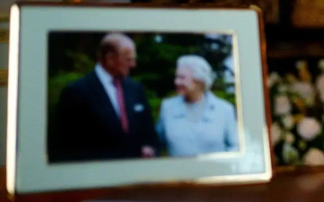 La reina suele mostrar fotografías de sus hijos, nietos y bisnietos en su escritorio durante su discurso. El año pasado, la Reina mostró una sola foto del Príncipe Felipe después de que la pareja pasó nueve meses encerrados juntos. De manera similar, para 2021, en el escritorio de la Reina, solo había una foto enmarcada que mostraba a la Reina y su esposo, el Príncipe Felipe juntos. La foto fue tomada en 2007 en la casa de campo de Broadlands en Hampshire cuando marcaron su aniversario de bodas de diamantes.