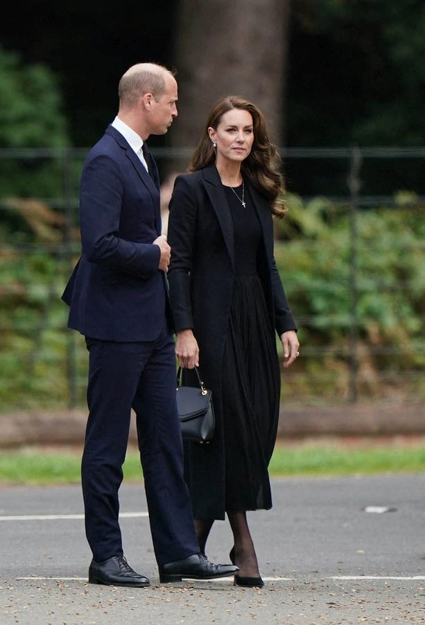 Kate, la nueva Princesa de Gales, apoya con dignidad a su esposo en su nuevo rol. Su atuendo sobrio, pero elegante y la joya reducida son muy apropiados para esta ocasión. Perfecta como siempre, incluso durante este triste momento.