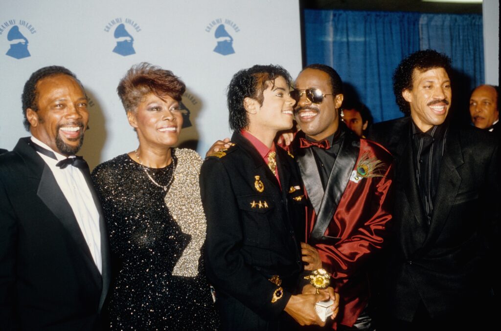 LOS ANGELES – FEBRUARY 25:  Michael Jackson and his producer Quincy Jones with Dionne Warwick, Stevie Wonder and Lionel Richie pose for photos backstage on February 25 1986 at the 28th annual Grammy Awards at the Shrine Auditorium in Los Angeles, California. (Photo by Michael Ochs Archive/Getty Images)